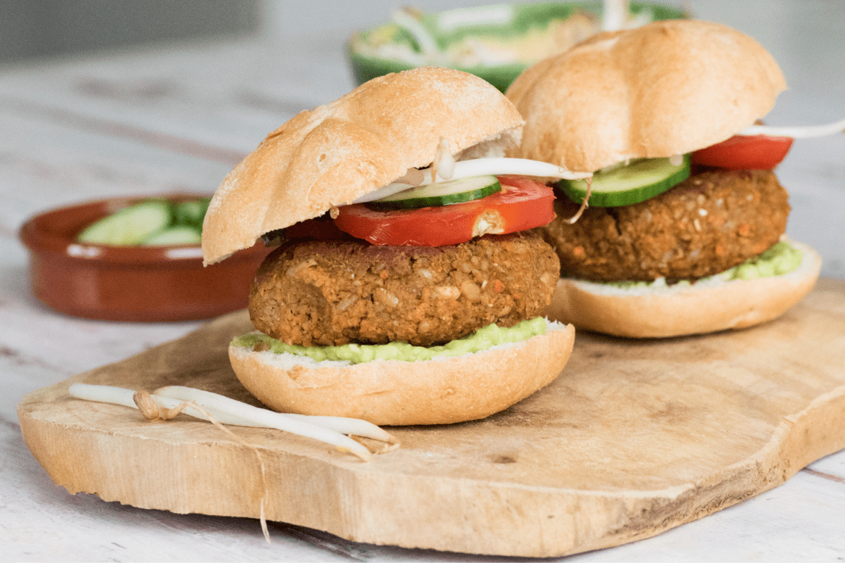 Zelfgemaakte kikkererwten burger op een hamburger broodje met sla, tomaat en tauge.