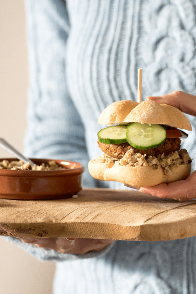 Kikkererwten burger op een hamburger broodje met sla, tomaat en tauge.